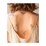 Una serie di immagini potenti: un pugnale con la scritta "Sans Rancune" (senza rabbia), una falena, una rosa e due armi, una in una mano e una in un pugno insanguinato. Questo tatuaggio unisce forza, pace e dolore in modo potente e simbolico.