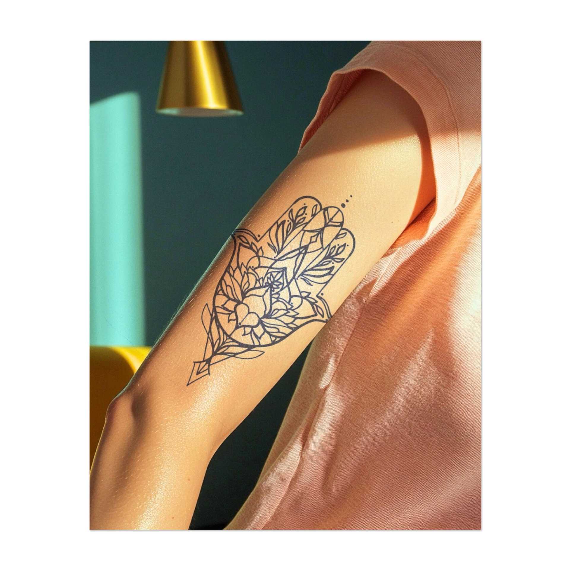Una mano di Hamsa decorata con motivi floreali. Questo simbolo protegge dalla negatività e porta fortuna. È un simbolo significativo di pace e protezione.