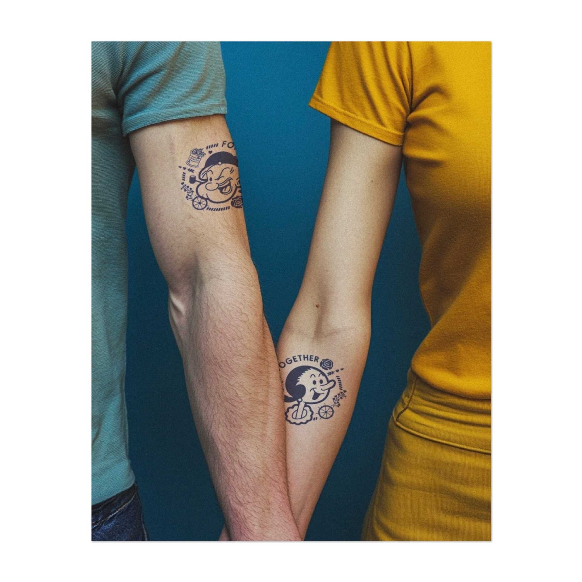 Una serie di tatuaggi giocosi raffiguranti Braccio di Ferro e Olivia, accompagnati dalle parole "Per sempre" e "Insieme". Circondati da ancore, rose e cuori, simboleggiano amore e lealtà nello stile dei vecchi cartoni animati.