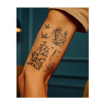 Un set di simboli classici: due uccelli in volo, un ferro di cavallo con fiori e la scritta "BUONA FORTUNA", una barca che solca le onde e un pugnale con fiori. Questi disegni catturano lo spirito avventuroso, la speranza e la protezione del viaggio di un marinaio.