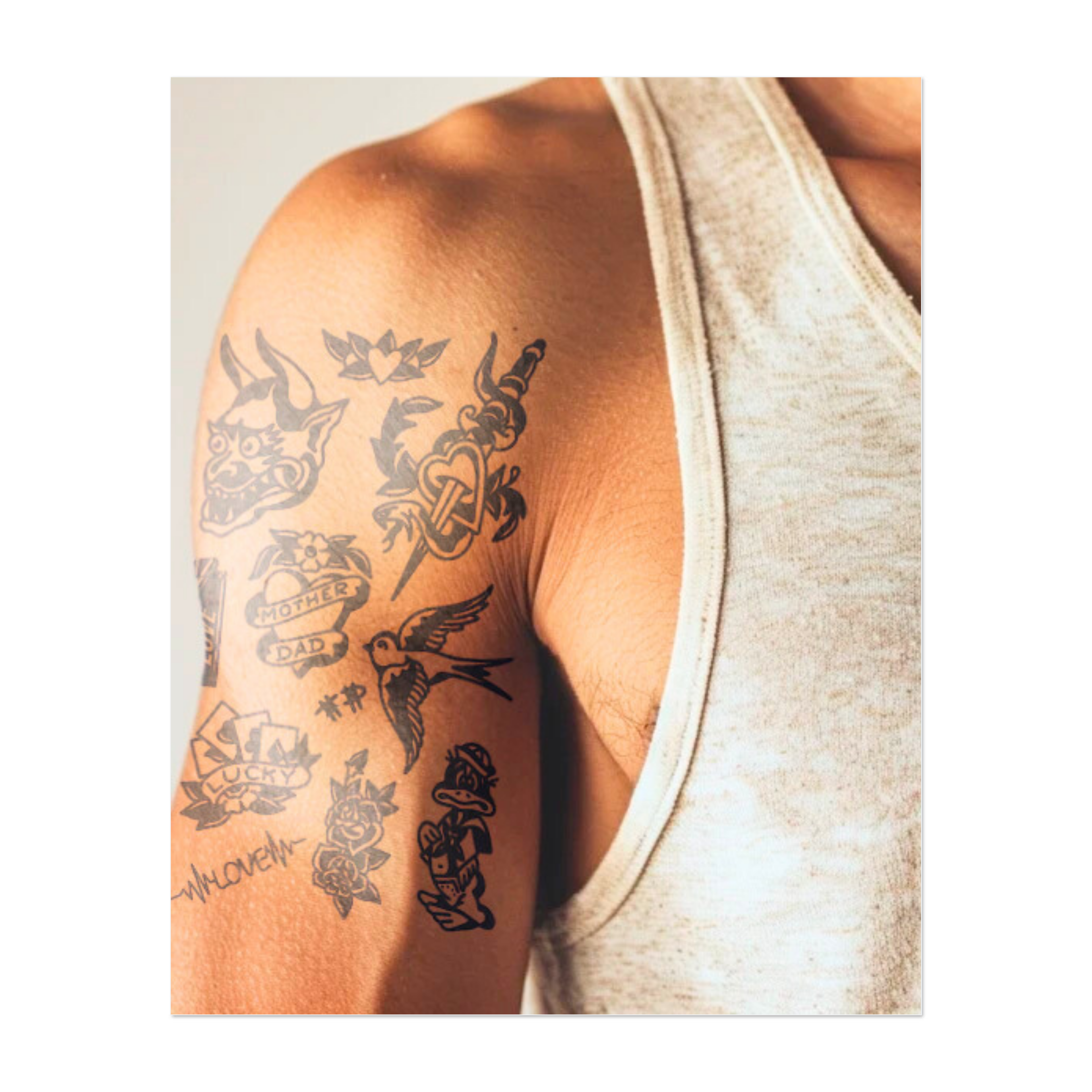 Un mucchio di vecchi tatuaggi divertenti: una faccia da diavolo, un lecca-lecca a forma di cuore, un uccello che vola, rose e messaggi come "AMORE", "MAMMA", "PAPÀ", "FORTUNATO" e "DONNA".