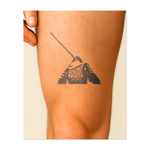 Un temibile samurai con una spada sulla schiena si erge forte in battaglia. Questo tatuaggio rappresenta onore, resilienza e spirito guerriero.