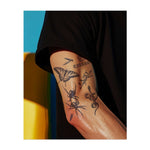 Un insieme di simboli audaci e spigolosi: una farfalla, un ragno, un serpente, proiettili e le parole "KILLER" e "LUST". Questi disegni rappresentano pericolo, tentazione e potere, combinando la bellezza oscura con l'energia grezza e selvaggia.