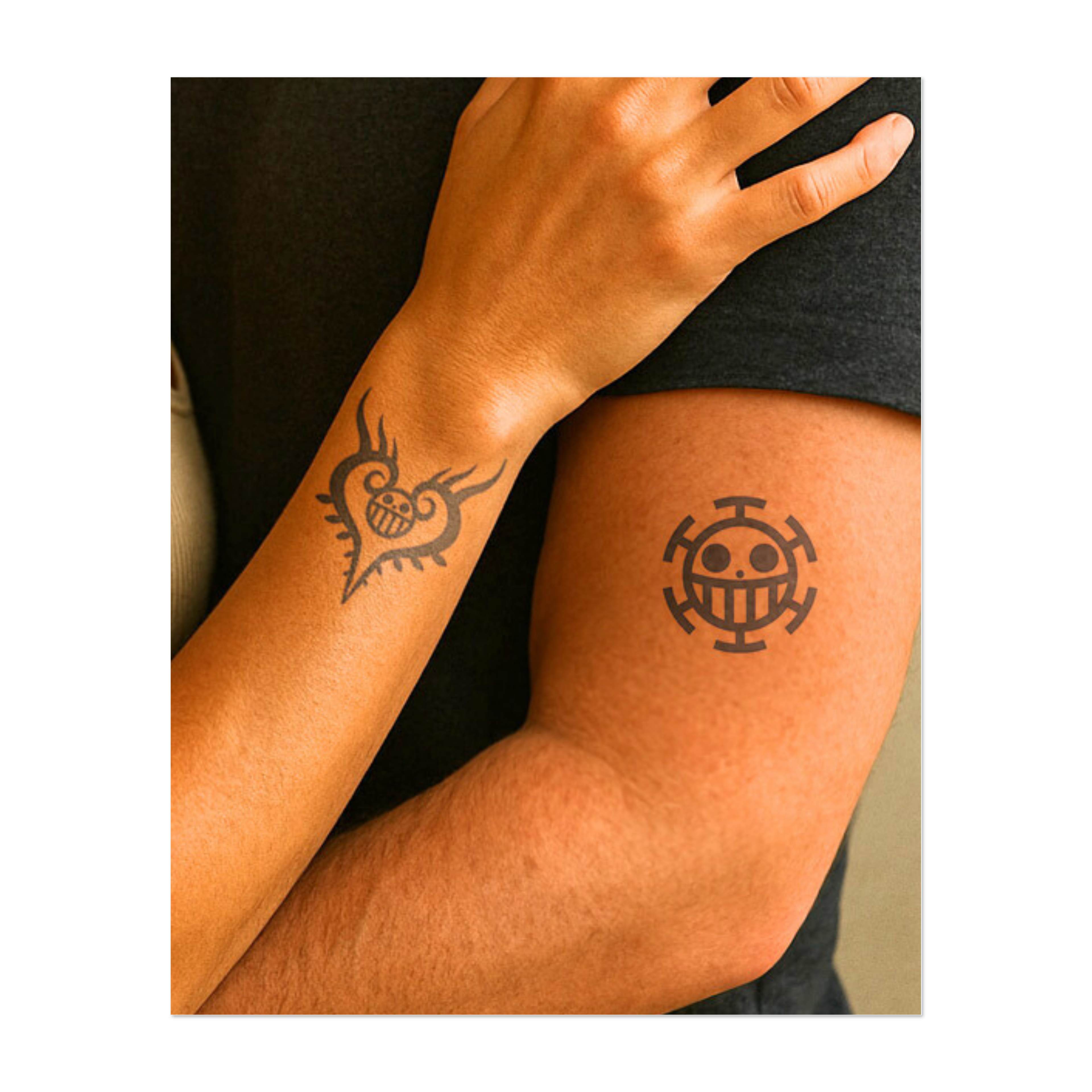 Un tatuaggio raffigurante il Jolly Roger di One Piece, con l'iconico teschio sorridente e le ossa incrociate. Il primo disegno è il simbolo dei Pirati di Cappello di Paglia, il secondo ha una cornice a forma di cuore. Un tributo perfetto per i fan dell'avventurosa ciurma di Rufy!