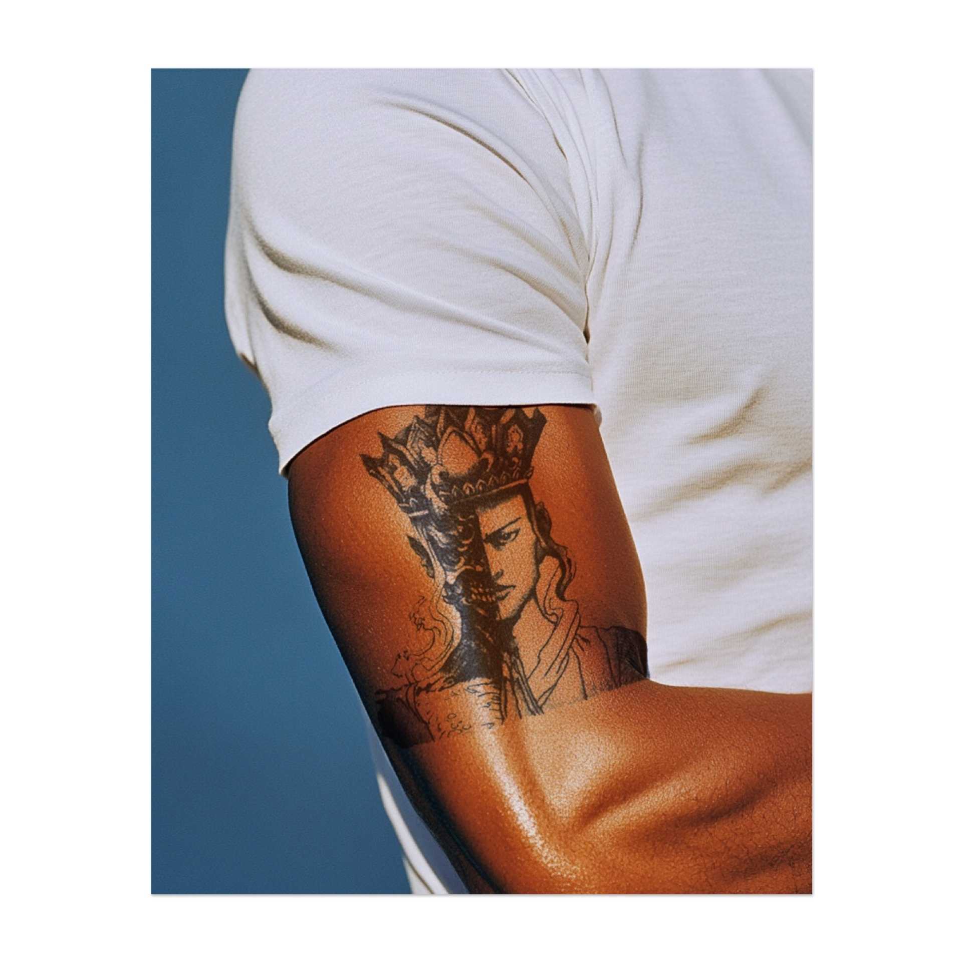 Un tatuaggio del volto di un re che indossa una corona, con metà del viso che esprime nobiltà e l'altra metà nascosta nell'ombra. Questo disegno rappresenta l'equilibrio tra potere e vulnerabilità e simboleggia la leadership, la forza e la dualità della natura umana.