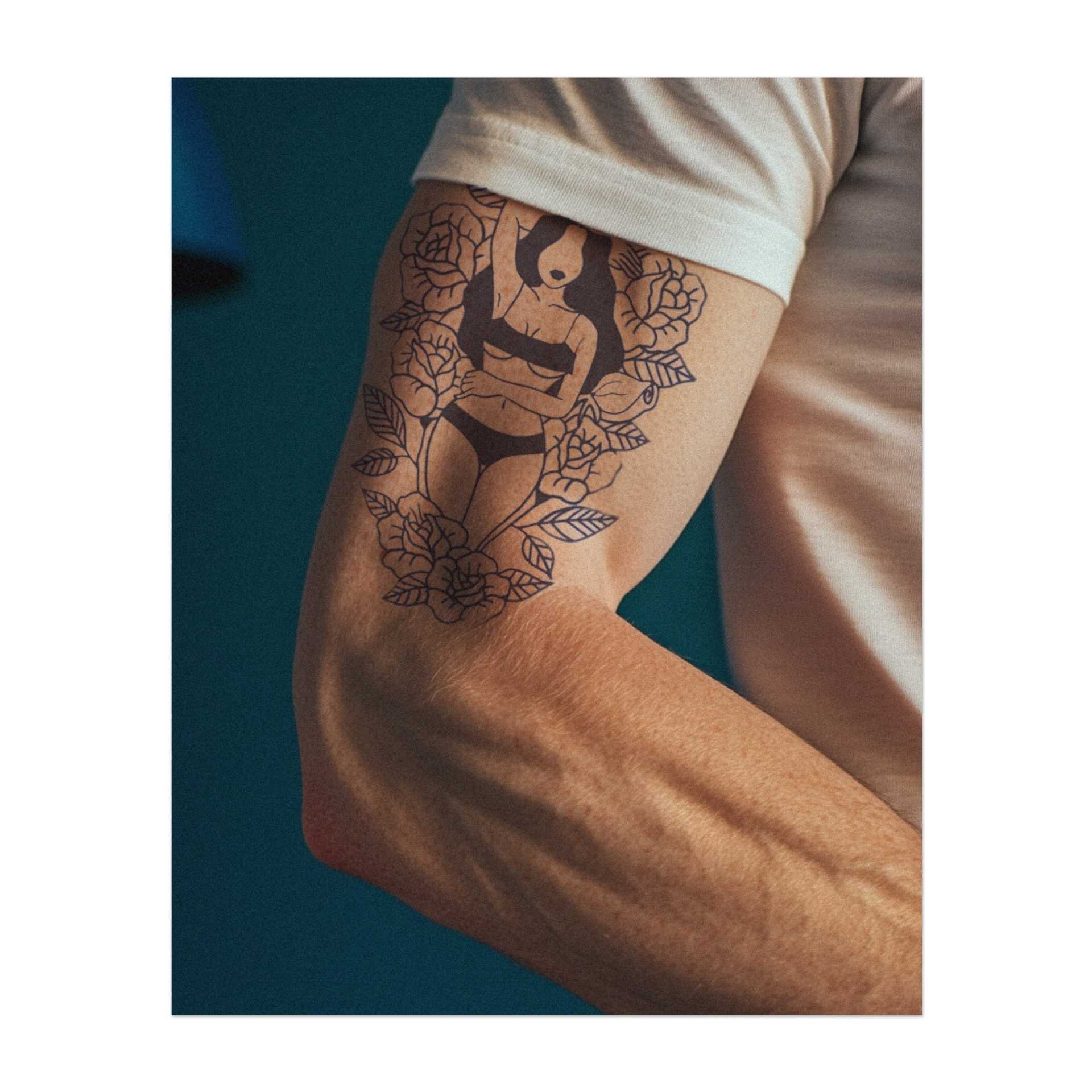 Una donna aggraziata circondata da rose, incarna bellezza e sicurezza. Con la sua postura rilassata, questo tatuaggio simboleggia femminilità ed eleganza. Un disegno perfetto per chi apprezza la propria forza interiore e ama il delicato fascino della natura.