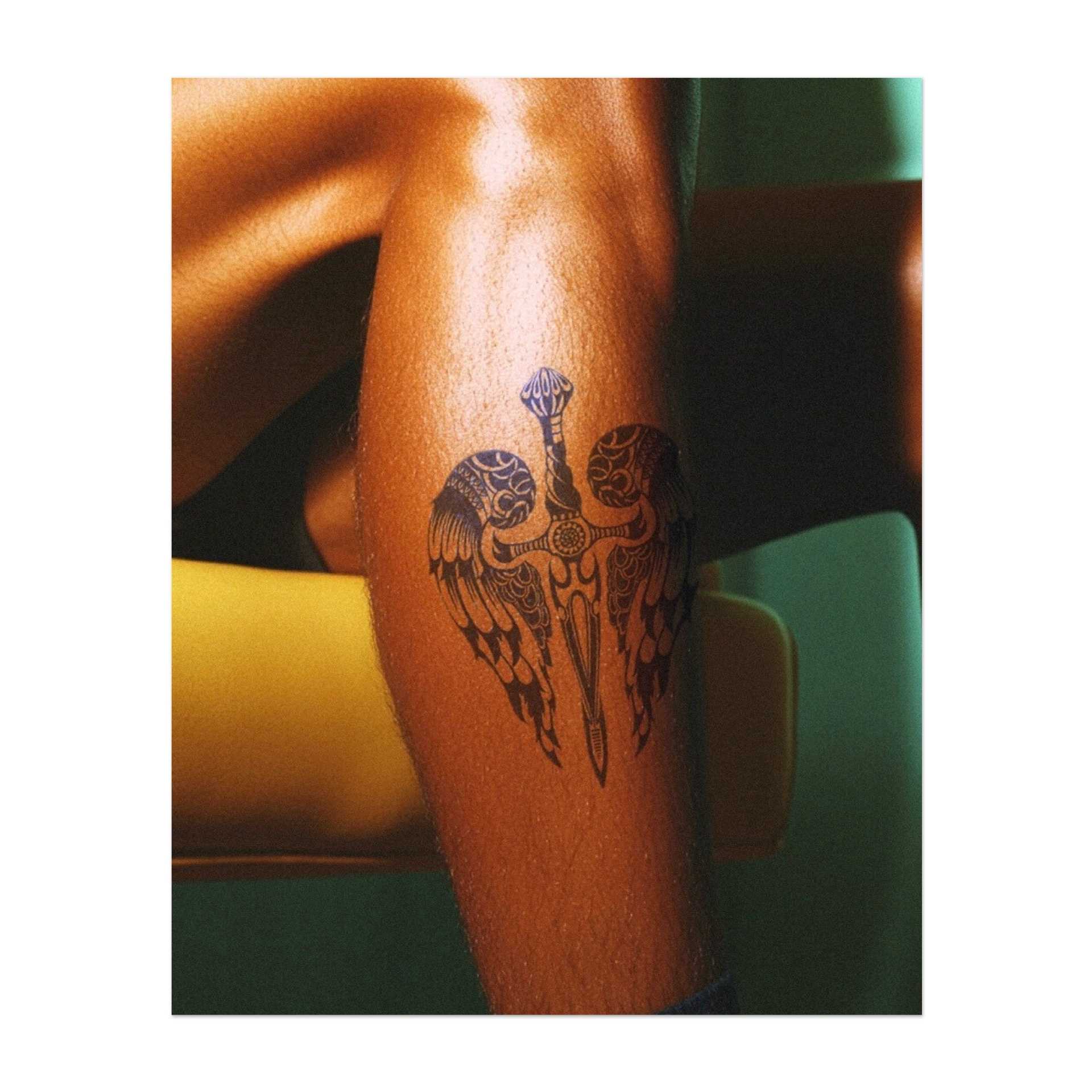 Una spada dettagliata con ali che si estendono da entrambi i lati simboleggia l'equilibrio tra forza e grazia. Questo tatuaggio rappresenta protezione, coraggio e potere divino ed è ideale per chi apprezza sia il coraggio che la pace interiore.