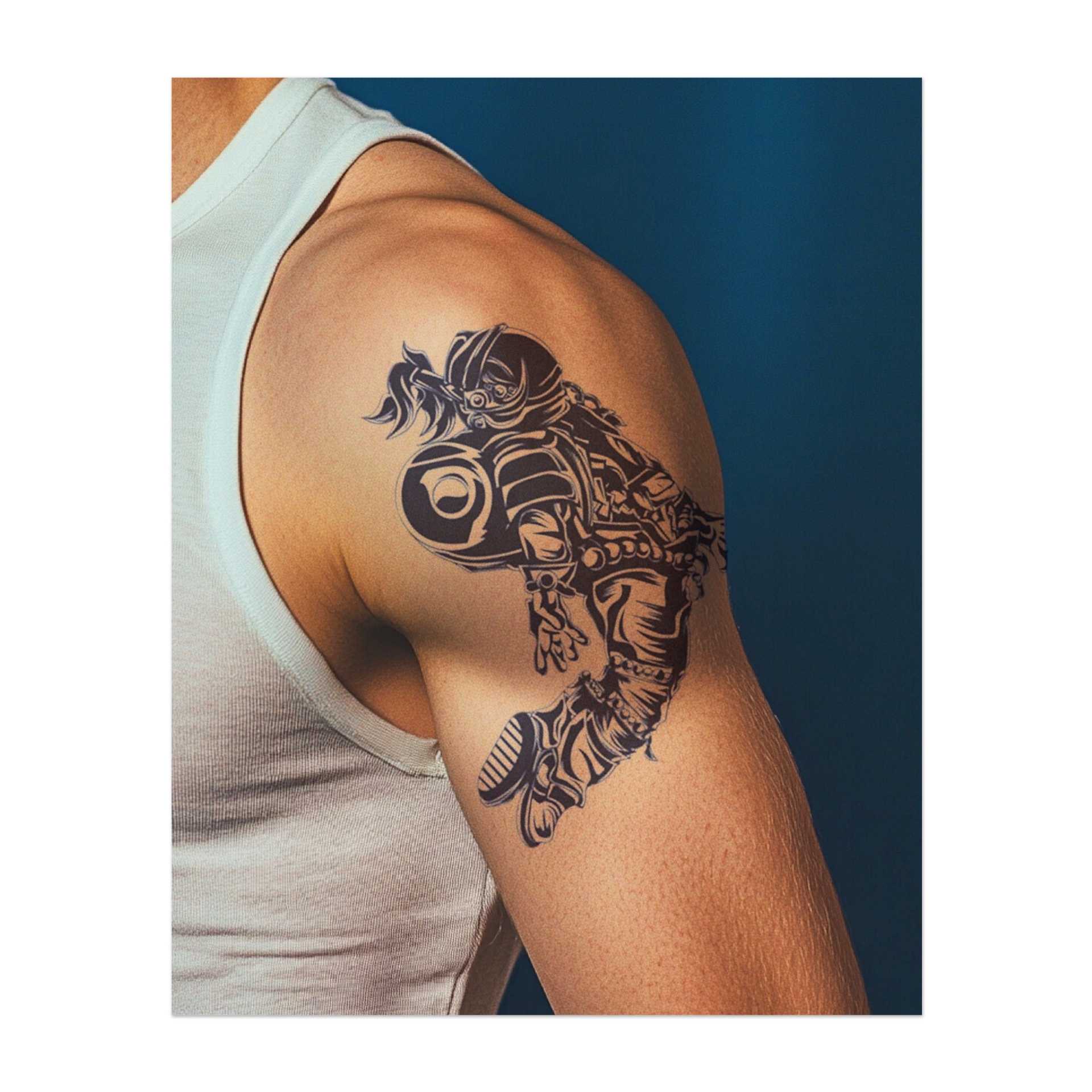 Un tatuaggio dinamico di un astronauta in equipaggiamento completo che si lancia nello spazio. Questo disegno simboleggia la scoperta, l'avventura e la ricerca dell'ignoto. Perfetto per chi sogna avventure oltre la Terra o apprezza lo spirito di scoperta.