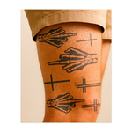 Un tatuaggio ribelle raffigurante mani scheletriche con il dito medio in evidenza e croci. Il disegno fonde umorismo nero con elementi religiosi simbolici e rappresenta una coraggiosa dichiarazione di resistenza e individualità. Ideale per chi ama superare i propri limiti.