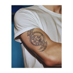 Un tatuaggio dinamico con una figura centrale circondata da motivi tribali vorticosi. La croce e le linee nette rappresentano equilibrio e potenza, mentre la figura centrale aggiunge un senso di mistero e profondità. Perfetto per chi abbraccia sia la forza interiore che l'energia della trasformazione.