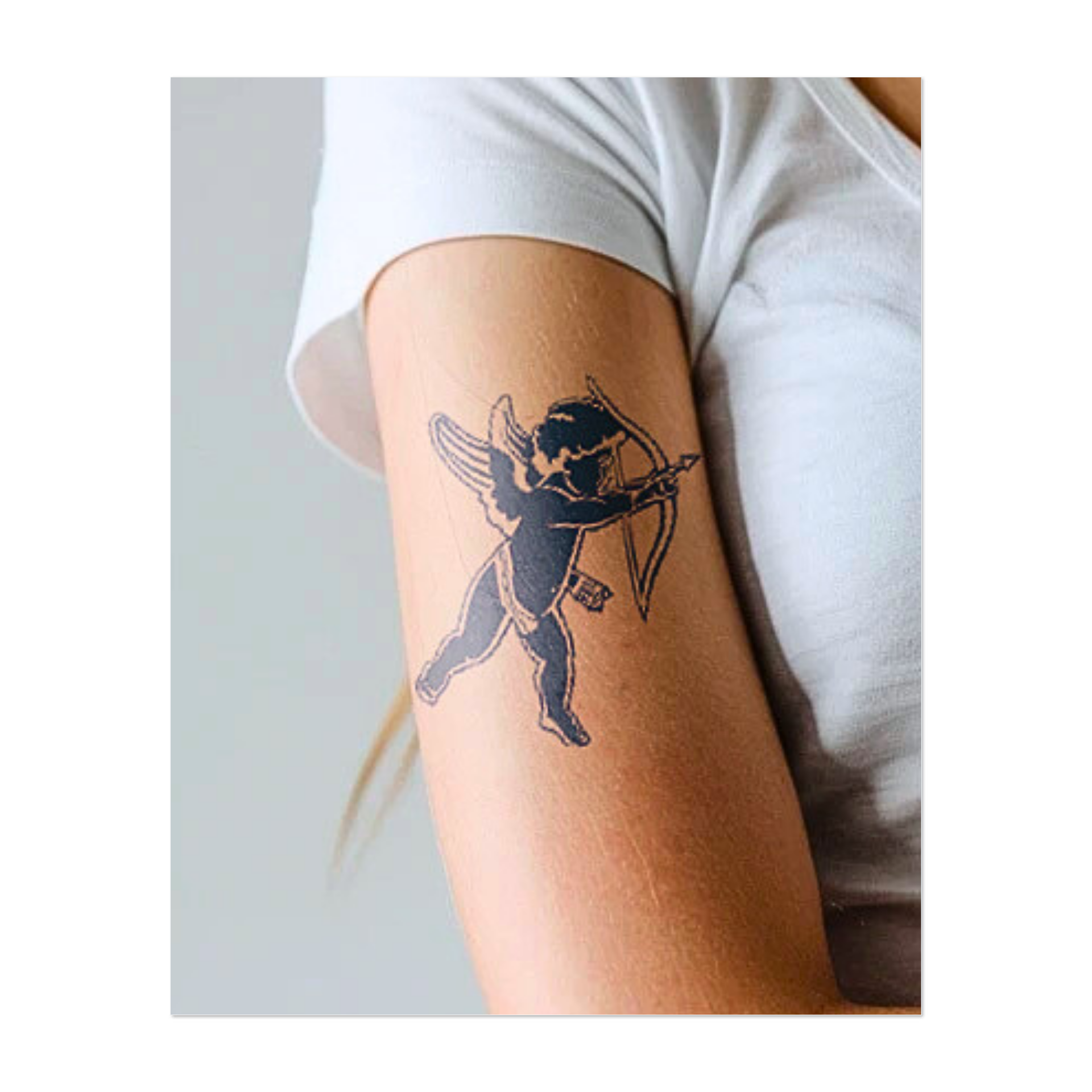 Un tatuaggio giocoso e romantico di Cupido, il dio dell'amore, pronto a colpire con arco e frecce. Questo disegno simboleggia l'amore, la passione e il potere della connessione ed è perfetto per chi crede nella magia dell'amore e del destino.