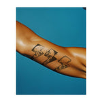 Un tatuaggio che raffigura frammenti frastagliati e spigolosi di spazio frantumato, ognuno dei quali rivela un'immagine diversa di un teschio o di una mano. Il disegno frammentato rappresenta il tema della rottura e della trasformazione e simboleggia la forza di superare le avversità.