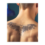 Un angelo con grandi ali fluenti spiegate, che fluttuano nell'aria. Il movimento delle ali e la silhouette trasmettono un senso di libertà e di volo. Il tatuaggio cattura la sensazione di forza, grazia e liberazione.
