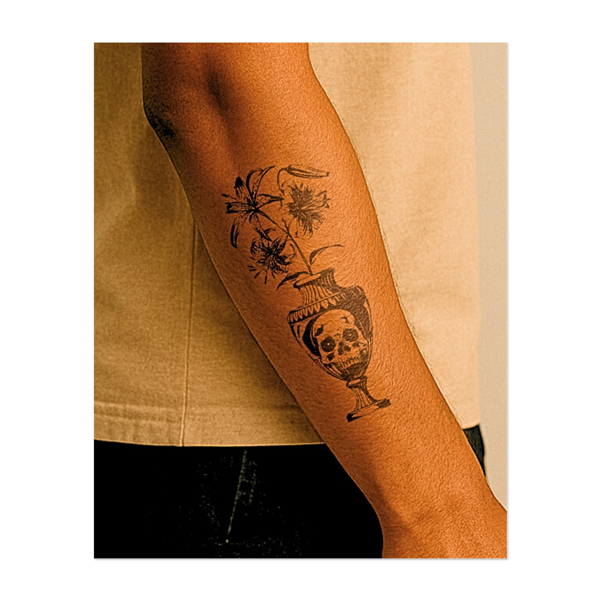 Questo sorprendente tatuaggio raffigura eleganti gigli che emergono da un'urna classica contenente un teschio dagli occhi incavati. Il disegno contrappone vita e morte, bellezza e decadenza, affrontando la caducità dell'esistenza e l'inquietante eleganza della memoria.