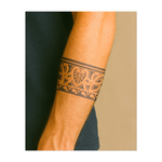 Un audace disegno tribale avvolto in un motivo continuo, con linee e curve elaborate. Questo tatuaggio a fascia simboleggia forza, unità e patrimonio culturale e offre un look sorprendente ma minimalista.