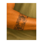 Un potente tatuaggio a nastro raffigurante il volto di Gesù, incorniciato da rose e spine. Questo tatuaggio simboleggia fede, sacrificio e forza spirituale, catturando emozioni profonde e devozione.