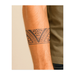 Un tatuaggio a fascia dettagliato con motivi tribali simmetrici, linee nette e curve. Questo tatuaggio simboleggia forza, equilibrio e unità, combinando precisione geometrica e movimento fluido.