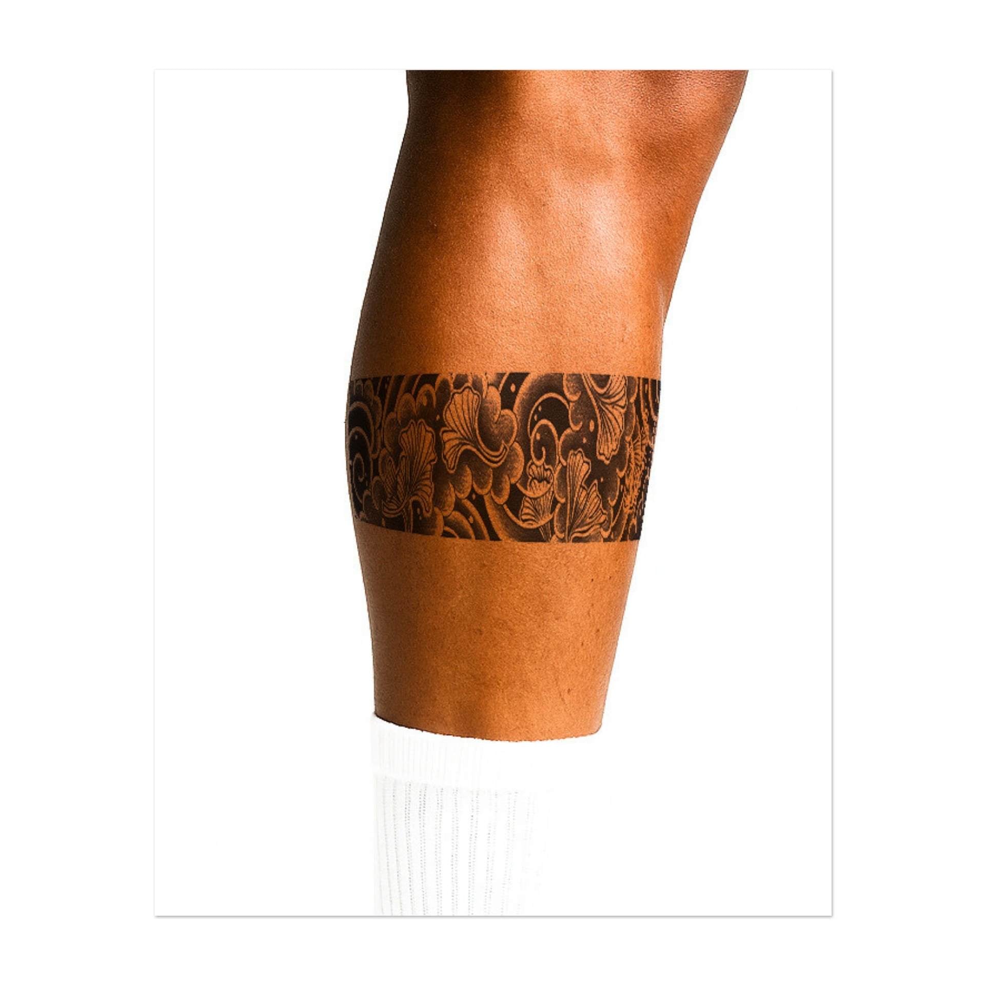 Un grazioso disegno a nastro con nuvole vorticose e delicate foglie di ginkgo mosse dal vento. Questo tatuaggio simboleggia la resilienza, la pace e la bellezza dei cicli naturali.