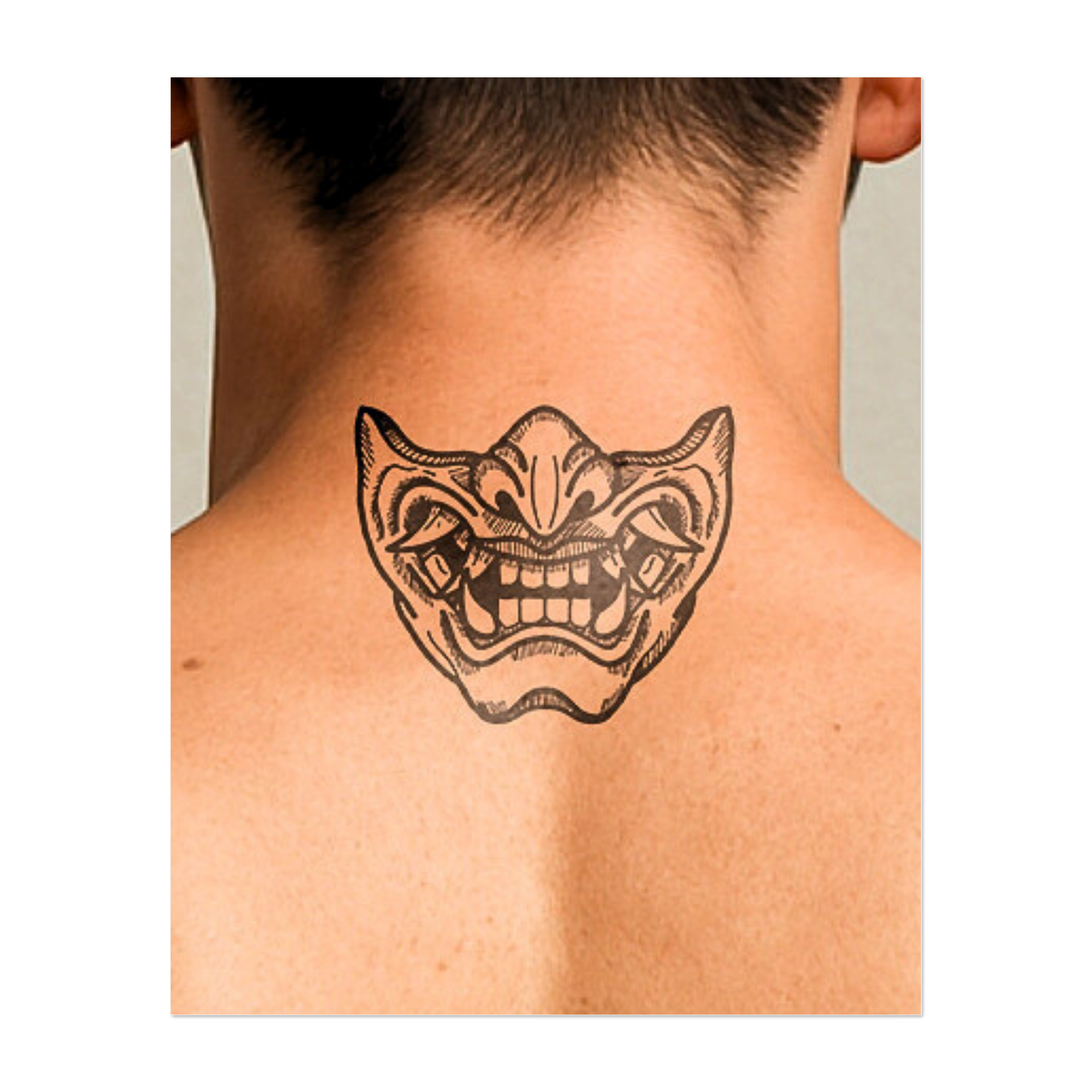 Questo sorprendente tatuaggio raffigura una maschera demoniaca stilizzata con tratti esagerati e un ampio sorriso sdentato. Ispirato ai tradizionali disegni oni giapponesi, rappresenta caos, protezione e pura emozione: un mix di minaccia e misticismo in un sorprendente design scolpito.