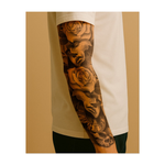 Questo tatuaggio drammatico combina maschere teatrali classiche con rose in fiore, un orologio rotto e delicati motivi a forma di teschio. Cattura il passare del tempo, la dualità di gioia e tristezza e la bellezza che permane anche nei momenti più bui della vita.