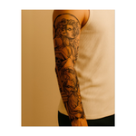 Questo tatuaggio è una potente composizione tratta dalla mitologia greca e raffigura Medusa con i capelli serpentiformi, uno squalo feroce nel mezzo della battaglia e Poseidone con il suo tridente. Circondato dalla flora marina, incarna il misticismo, il pericolo e la potenza selvaggia degli antichi dei.