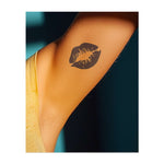 Un primo piano di labbra in un bacio appassionato, che mette in risalto le linee decise e i dettagli intricati. Questo tatuaggio simboleggia amore, passione e intimità, perfetto per chi celebra il potere della connessione e del desiderio.