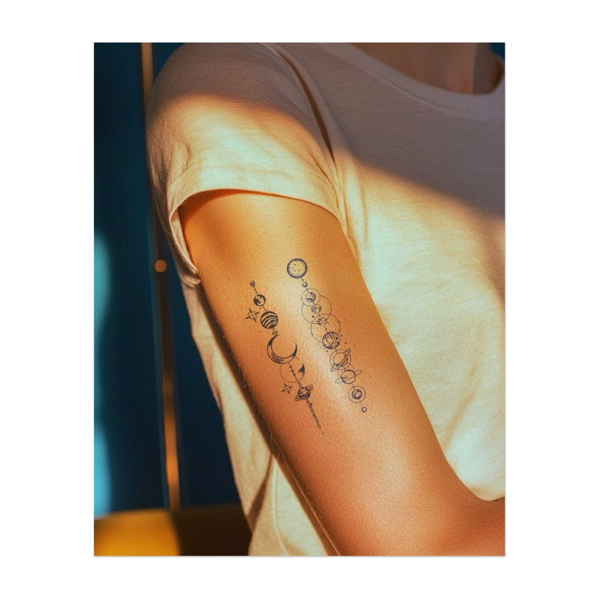 Una straordinaria combinazione di corpi celesti, tra cui lune, pianeti e stelle, collegati da orbite complesse. Questo tatuaggio simboleggia il vasto universo, l'equilibrio e l'armonia tra il cosmo e l'individuo.