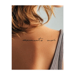 Una semplice iscrizione manoscritta con la frase latina "memento mori". La scrittura elegante e fluida ricorda con grazia la caducità della vita e invita alla consapevolezza e alla riflessione interiore.