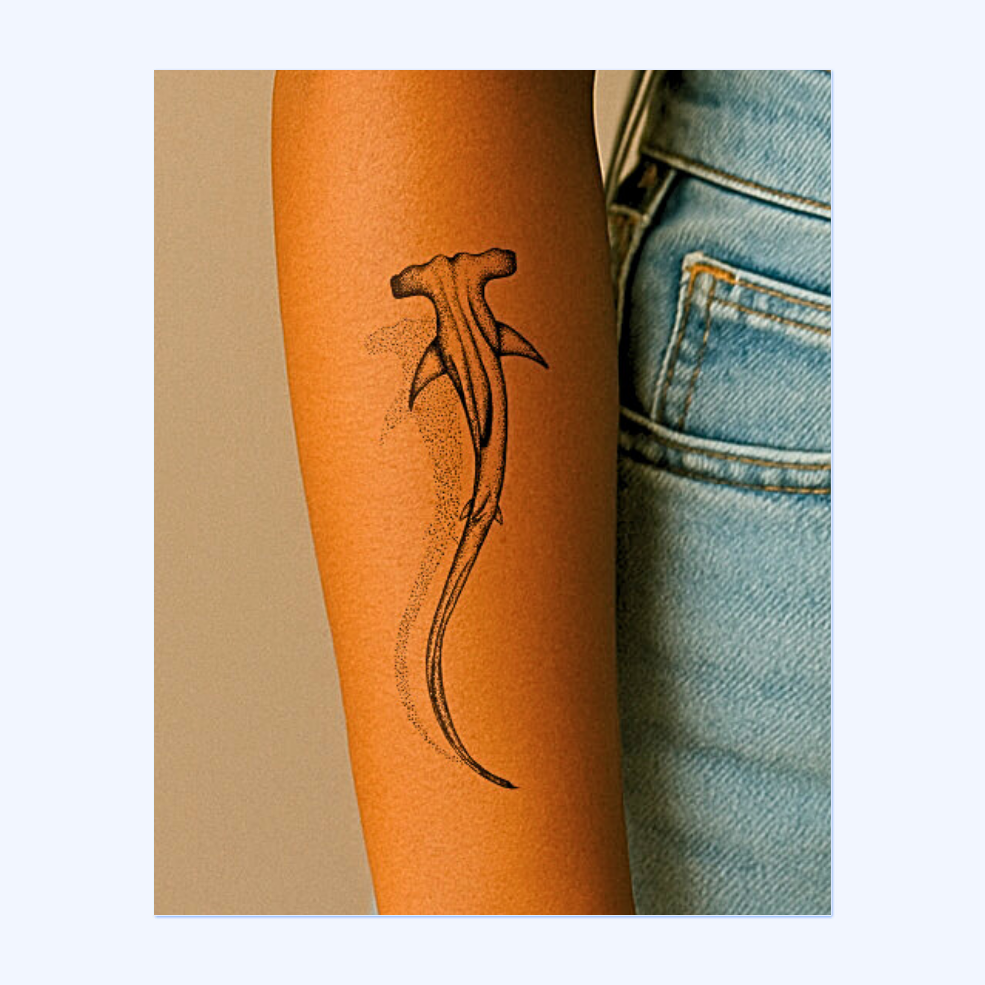 Un tatuaggio sorprendente raffigurante uno squalo martello stilizzato, disegnato con linee tratteggiate dettagliate. La forma dinamica e le ombre punteggiate conferiscono al disegno profondità, movimento e una misteriosa atmosfera marina.