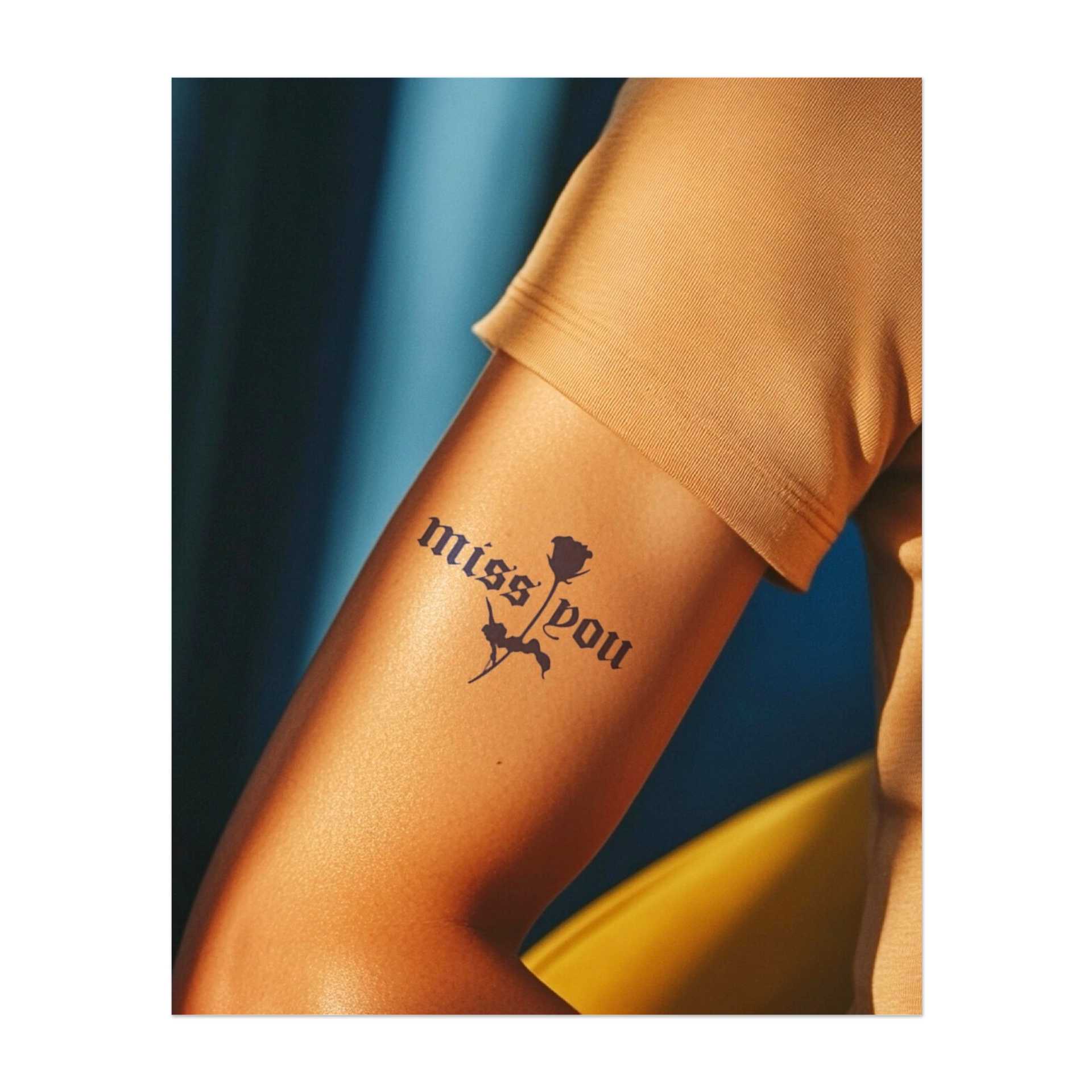 Un disegno sentimentale con le parole "Mi manchi" abbinate a una delicata rosa. Evoca amore e perdita ed esprime nostalgia e ricordi in un font bello ed elegante.