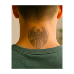 Un paio di ali maestose che circondano una croce simboleggiano protezione, forza e fede. Il disegno combina il potere divino con la libertà e rappresenta l'equilibrio tra guida spirituale e forza personale.