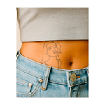 Un tatuaggio minimalista di una donna vestita casual che fuma una sigaretta. I suoi lunghi capelli svolazzano dolcemente e il fumo si diffonde nell'aria. Il disegno presenta linee pulite e semplici, che gli conferiscono un aspetto moderno e rilassato.