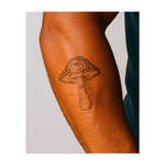 Un fungo surreale cresce, con un occhio onniveggente incastonato nel suo cappello ondulato. Questo tatuaggio temporaneo combina vibrazioni psichedeliche con un tocco di misticismo, suscitando curiosità e simboleggiando una maggiore consapevolezza e una percezione alterata.