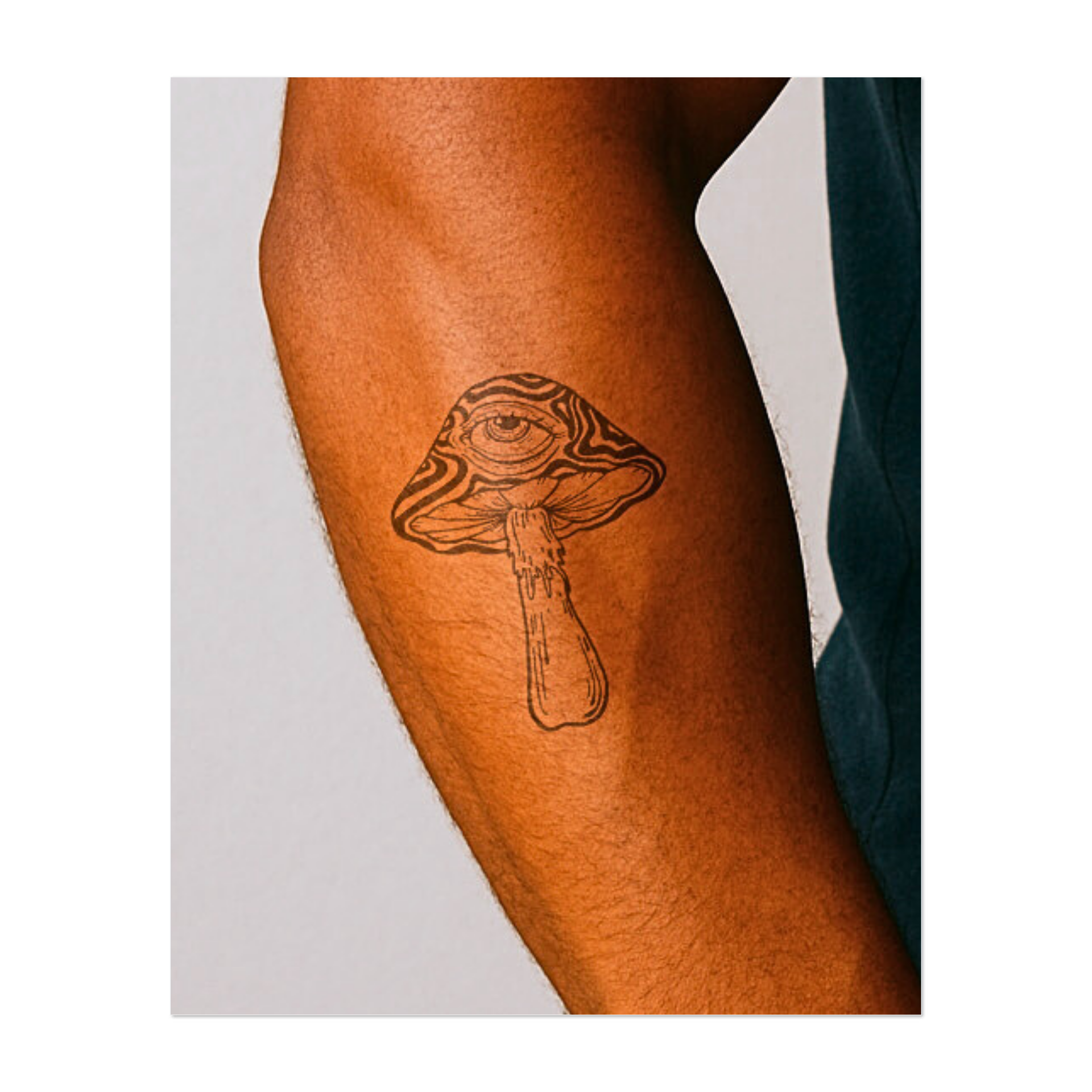 Un fungo surreale cresce, con un occhio onniveggente incastonato nel suo cappello ondulato. Questo tatuaggio temporaneo combina vibrazioni psichedeliche con un tocco di misticismo, suscitando curiosità e simboleggiando una maggiore consapevolezza e una percezione alterata.