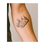 Questo sorprendente tatuaggio raffigura una pila di banconote da cento dollari strettamente stipate, avvolte da fiamme stilizzate. Rappresenta la transitorietà della ricchezza materiale e simboleggia il rischio finanziario, gli eccessi e il fascino autodistruttivo della ricerca della felicità a qualsiasi costo.