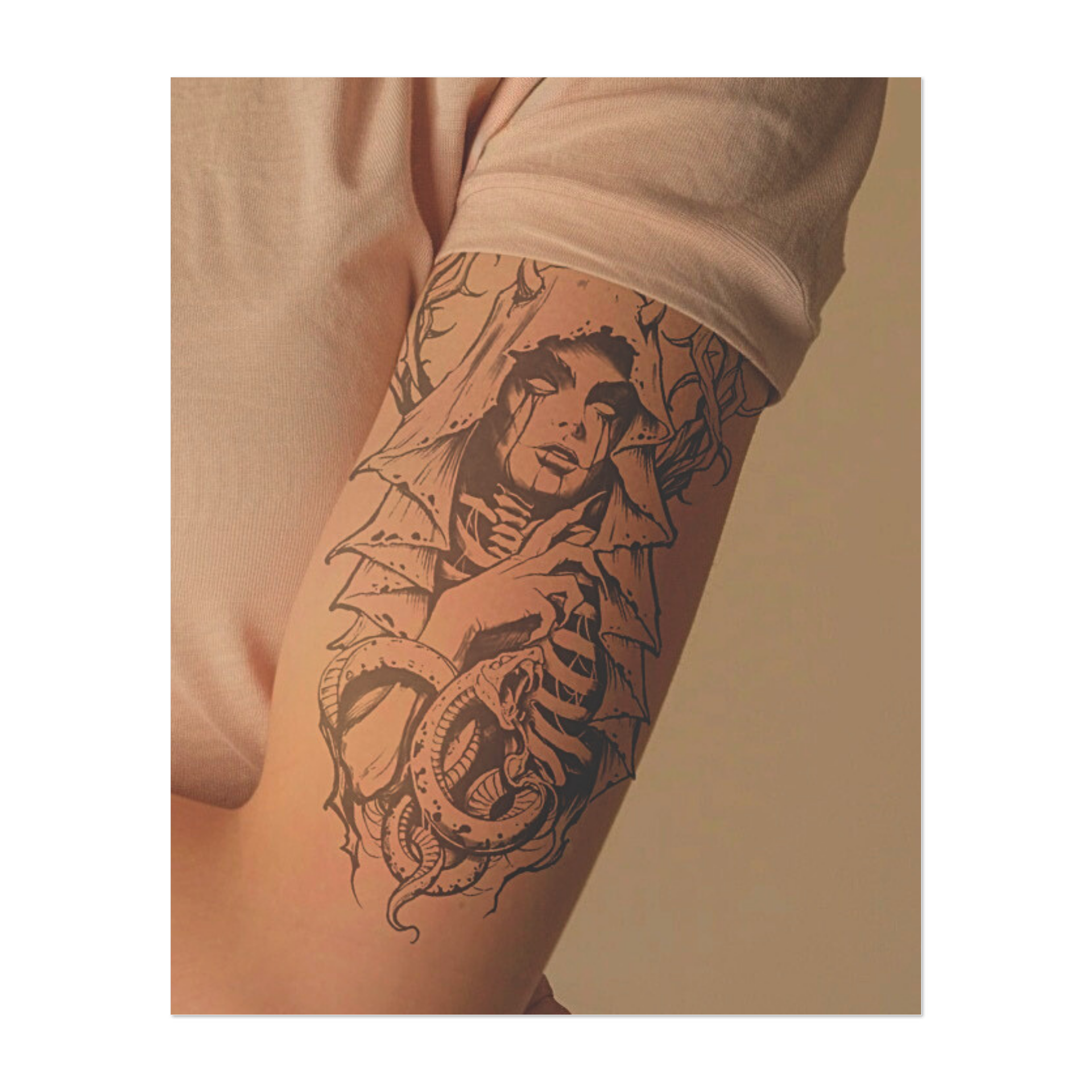 Una figura inquietante, avvolta in un sudario e circondata da una corona di spine, fissa davanti a sé con occhi insanguinati. Il suo corpo scheletrico, avvolto attorno a un serpente, conferisce all'insieme un'inquietante miscela di bellezza, decadenza e oscuro misticismo.