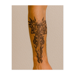 Questo potente tatuaggio raffigura un guerriero pesantemente corazzato, avvolto nell'oscurità, che impugna un'enorme spada puntata verso il basso. Con le sue spalline chiodate e l'elmo con cappuccio, la figura trasuda forza, disciplina e silenziosa vigilanza, incarnando l'eterno guardiano, forgiato nell'ombra e nell'acciaio.