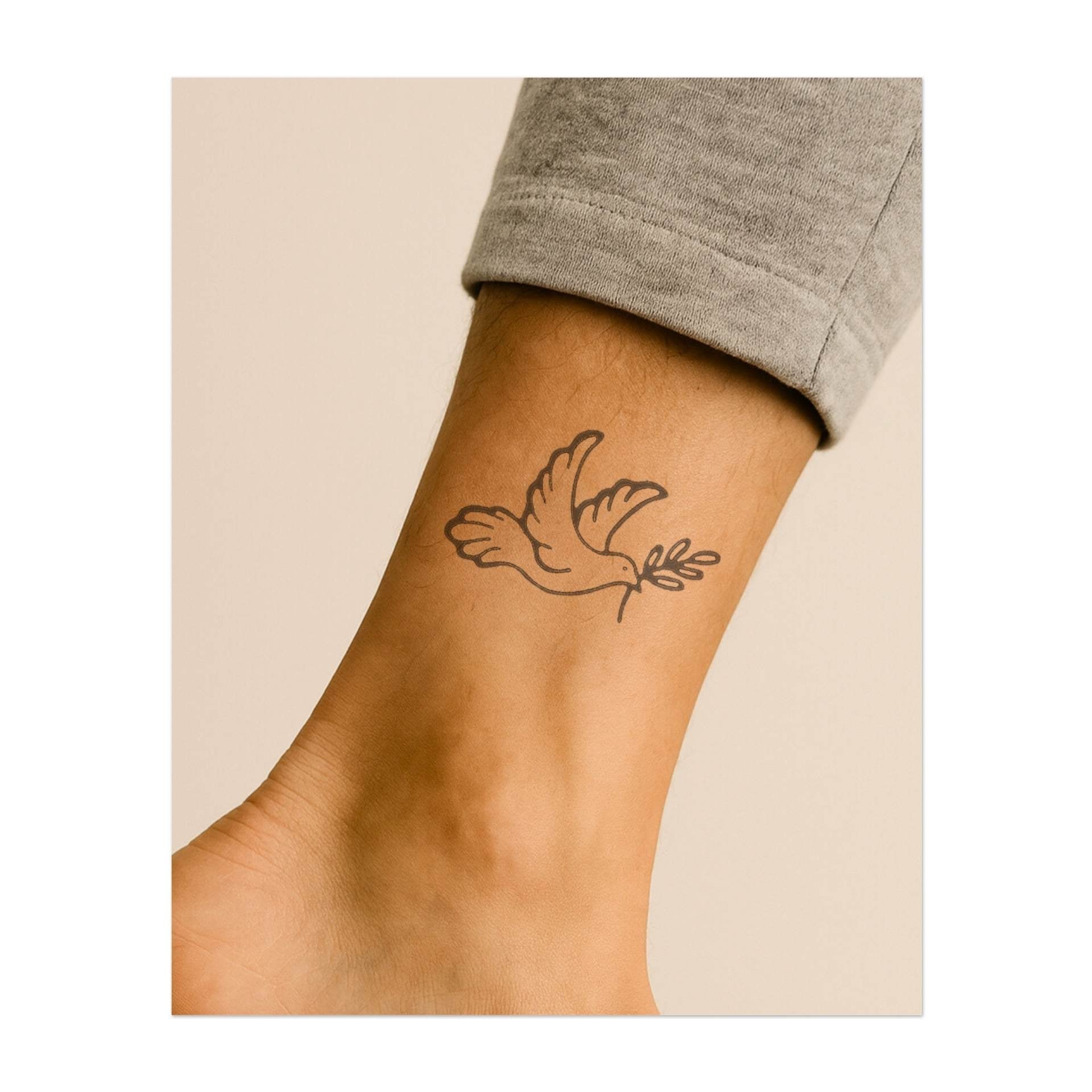 Una graziosa colomba che vola con un ramoscello d'ulivo nel becco. Questo tatuaggio simboleggia pace, speranza e armonia, perfetto per chi desidera diffondere amore e positività nel mondo.