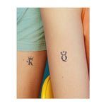 Una "K" e una "Q" stilizzate decorate con corone. Questo tatuaggio rappresenta la regalità, la forza e il legame tra due figure potenti, perfetto per chi apprezza la leadership e la connessione. Il Re e la Regina.