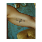 La parola "LOVER" in un carattere unico e irregolare, con un tocco giocoso e ribelle. Questo tatuaggio simboleggia amore, individualità e libertà di espressione, perfetto per chi celebra l'amore a modo proprio.