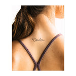 La parola "Papà" in una calligrafia fluida con un cuore sopra. Questo tatuaggio simboleggia amore, rispetto e connessione ed è perfetto per onorare una figura paterna con un gesto personale e sentito.