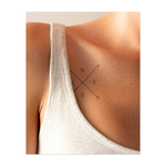 Un disegno minimalista a forma di bussola con frecce che puntano nelle quattro direzioni. Questo tatuaggio simboleggia l'orientamento, la direzione e la ricerca della propria strada, perfetto per chi cerca chiarezza e uno scopo nel proprio viaggio.