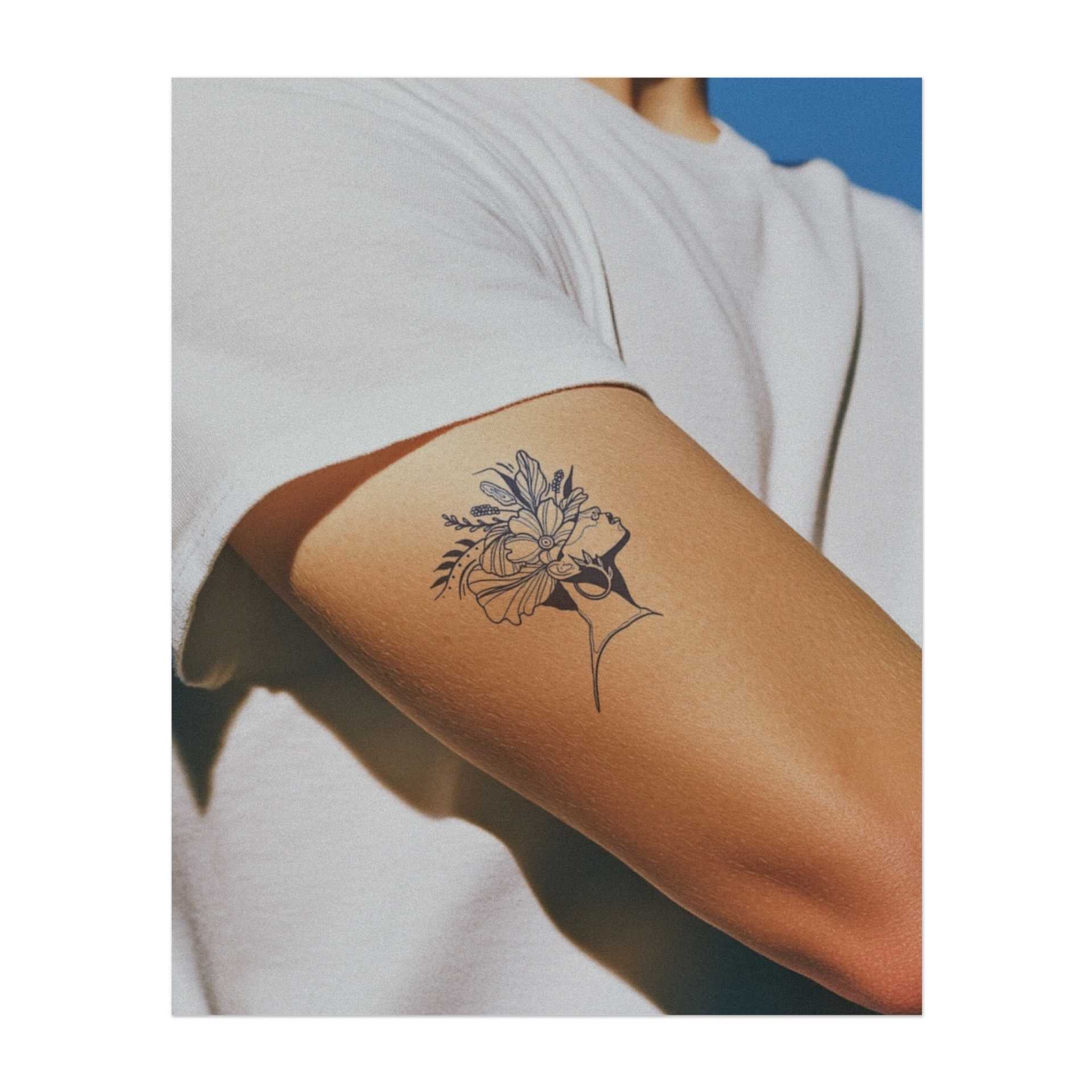 Un delicato profilo di donna con una corona di fiori e foglie dai colori vivaci. Questo tatuaggio simboleggia bellezza, natura e forza interiore. Perfetto per chi apprezza la grazia, la crescita e il potere della bellezza naturale.
