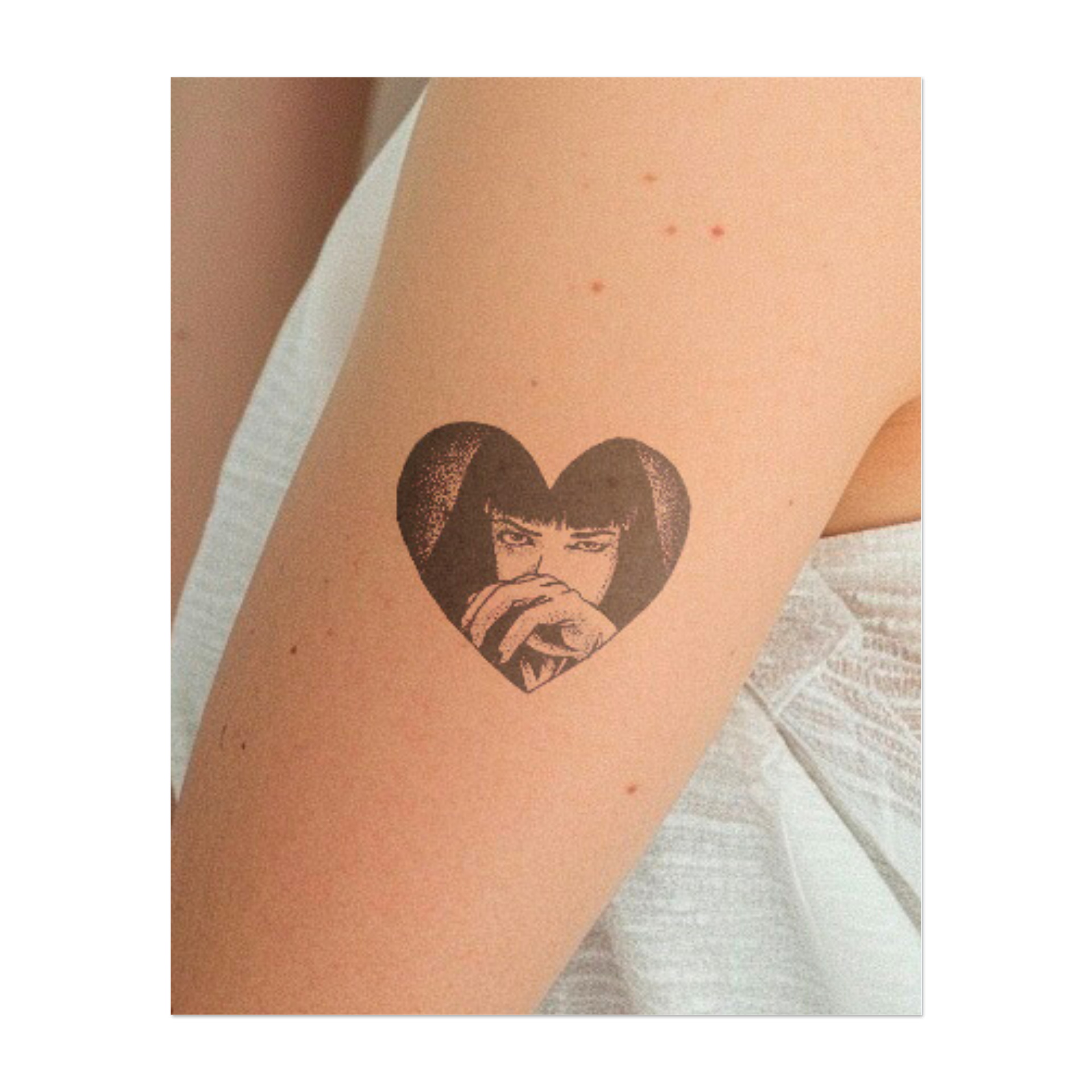 Una persona che guarda attraverso una cornice a forma di cuore con un'espressione misteriosa. Questo tatuaggio rappresenta mistero, vulnerabilità e profondità emotiva, perfetto per chi accetta la propria complessità interiore e protegge i propri sentimenti.