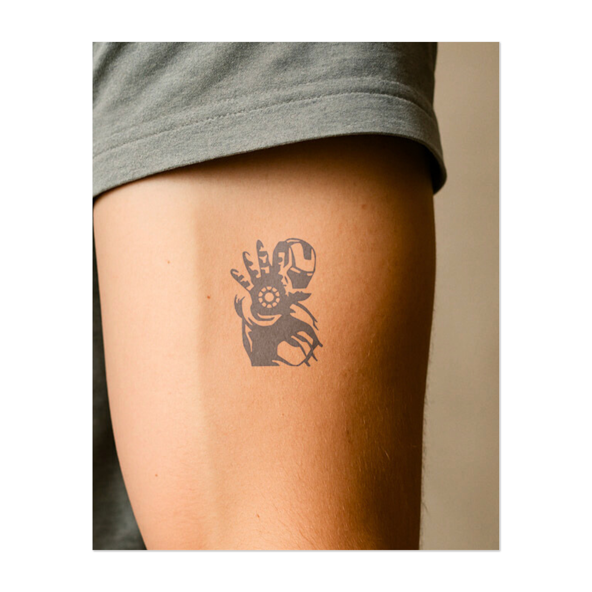 Un primo piano della mano corazzata di Iron Man, con un reattore ad arco luminoso. Questo tatuaggio simboleggia forza, tecnologia e resilienza, perfetto per chi apprezza l'innovazione, il coraggio e la forza di volontà.