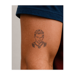 Un ritratto dettagliato di Lionel Messi che mostra la sua concentrazione e passione per il gioco. Questo tatuaggio simboleggia dedizione, talento e una spinta incessante verso la grandezza, perfetto per coloro che ammirano il suo talento e la sua etica del lavoro.