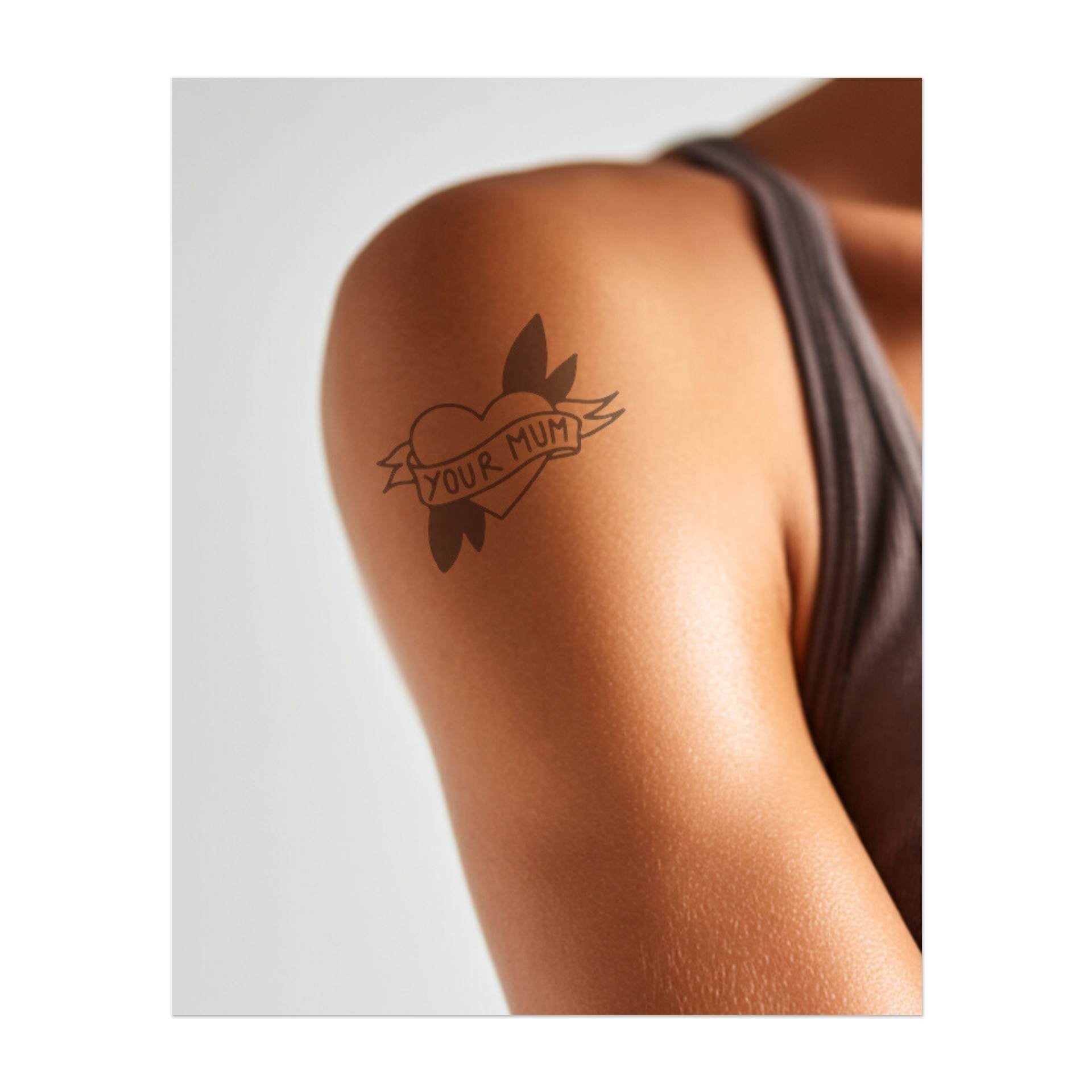 Un cuore intrecciato con uno striscione con la scritta "TUA MAMMA", circondato da foglie.