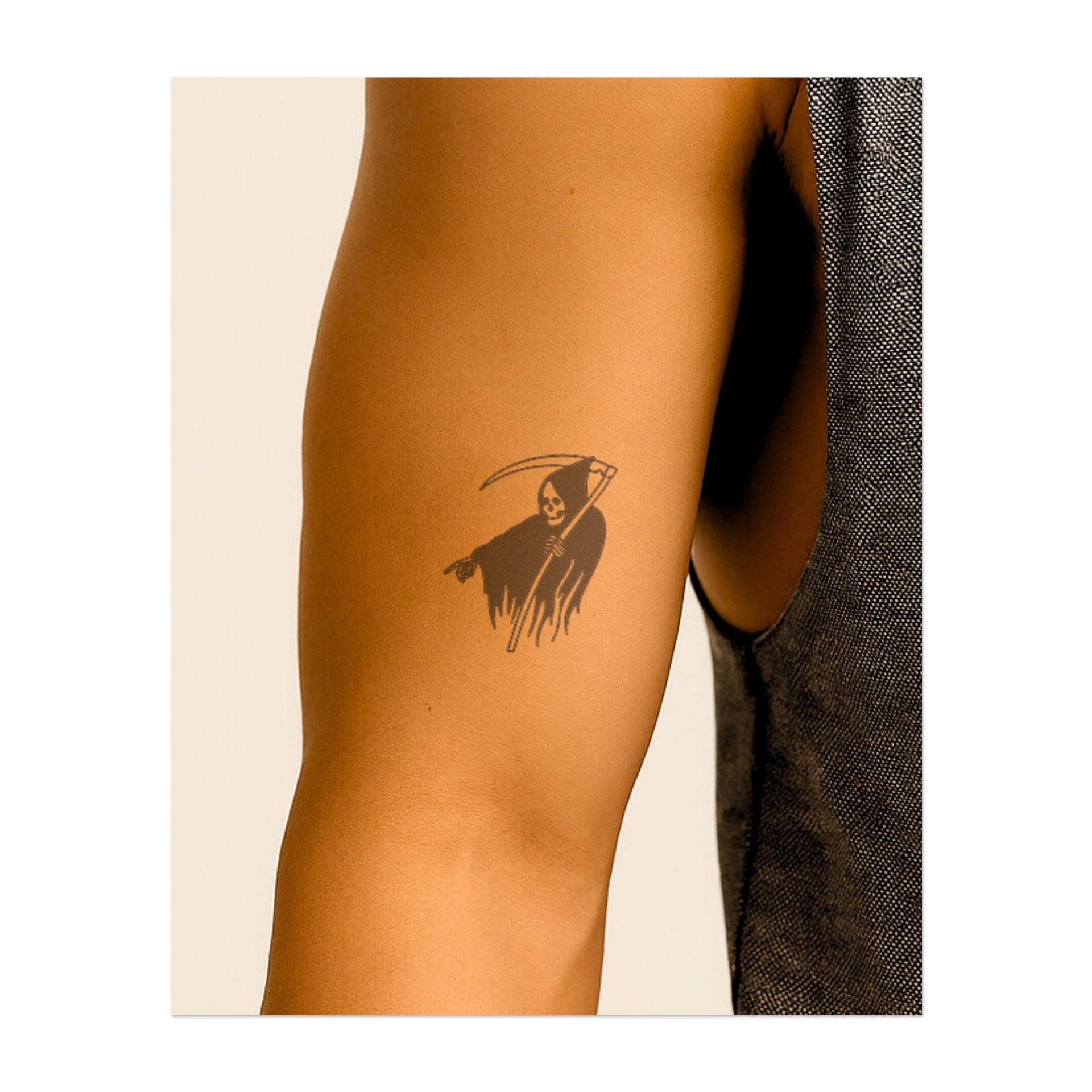 L'iconico Mietitore con la falce, simbolo della morte, della transizione e del ciclo della vita. Questo tatuaggio rappresenta l'inevitabile passare del tempo, ideale per chi accetta con calma il lato oscuro della vita.