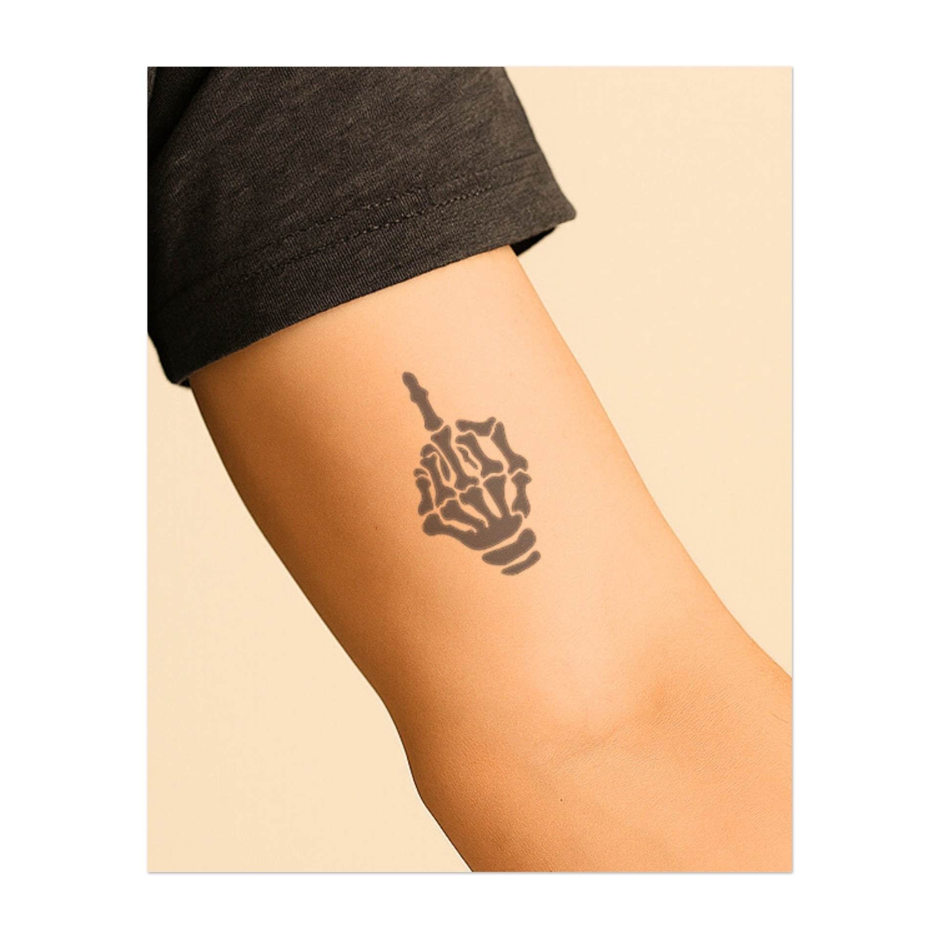 Una mano scheletrica che compie un gesto ribelle simboleggia la sfida e l'individualità. Questo tatuaggio rappresenta il vivere senza scuse, l'accettare la propria verità e la forza di fronte alle avversità.