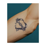 Un cuore avvolto da spine acuminate, da cui sgorgano lacrime. Questo tatuaggio simboleggia amore, dolore e sacrificio, rappresentando la complessità delle emozioni e la resilienza necessaria per sopportare il dolore e crescere.